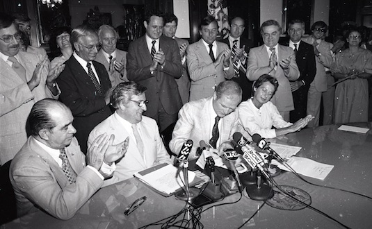 Signing documents at press conference